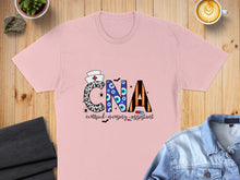 Load image into Gallery viewer, Pink t-shirt with "CNA certified nursing assistant" in Halloween-themed lettering.
