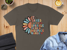Load image into Gallery viewer, T-shirt with colorful text "It takes a lot of sparkle to be a hospice nurse".
