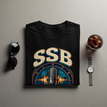 Load image into Gallery viewer, Black t-shirt with "SSB" and retro microphone graphic on world map background.
