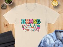 Load image into Gallery viewer, Cream t-shirt with colorful "Nurse" graphic and medical icons.
