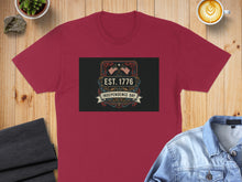 Load image into Gallery viewer, Maroon t-shirt with "EST. 1776 Independence Day" graphic featuring US flags.
