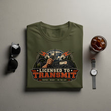 Load image into Gallery viewer, Green t-shirt with "Licensed to Transmit" graphic featuring radio equipment and mountains.
