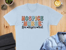 Load image into Gallery viewer, Light blue t-shirt with "Hospice Nurse Love Inspire Heal" in colorful retro font.
