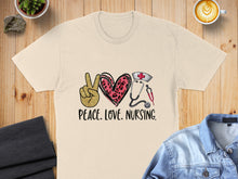 Load image into Gallery viewer, Cream t-shirt with "Peace. Love. Nursing." text, peace sign, heart, and stethoscope.
