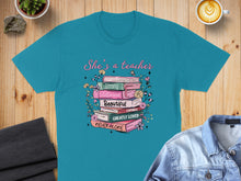 Load image into Gallery viewer, Teal t-shirt with "She's a teacher" and stacked books with inspirational words.
