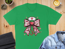 Load image into Gallery viewer, Green t-shirt featuring a pink nurse bow with stethoscope and cross.
