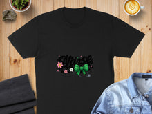 Load image into Gallery viewer, Black t-shirt with "Nurse" text, green bow, stethoscope, and pink flowers.
