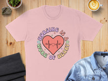 Load image into Gallery viewer, Pink t-shirt with text "Nursing is a work of heart" and a heart monitor.
