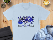 Load image into Gallery viewer, Light blue t-shirt with leopard print peace sign, heart, and dental graphics.
