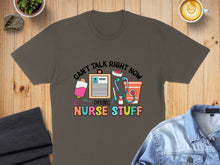 Load image into Gallery viewer, Brown t-shirt with "Can't Talk Right Now, Doing Nurse Stuff" and medical icons.
