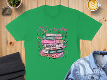 Load image into Gallery viewer, Green t-shirt with stacked books listing teacher qualities: Strong, Victorious, Beautiful, Capable, Greatly Loved, Never Alone.
