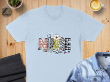 Load image into Gallery viewer, Light blue t-shirt with "NURSE" in colorful, patterned letters and medical accents.
