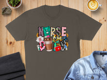 Load image into Gallery viewer, Nurse life graphic with coffee, stethoscope, and medical symbols on a brown t-shirt.
