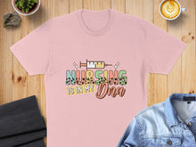 Load image into Gallery viewer, Pink t-shirt with "NURSING IS IN MY DNA" text and syringe graphic.

