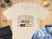 Load image into Gallery viewer, Beige t-shirt with "NURSE MODE ALL DAY EVERY DAY" text and band-aids.
