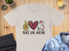 Load image into Gallery viewer, Cream t-shirt with "Peace. Love. Nursing." text and medical icons.
