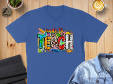 Load image into Gallery viewer, Blue t-shirt with "made to TEACH" text and colorful school supplies graphic.
