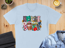 Load image into Gallery viewer, "NURSE LIFE" text design with medical icons and sunflowers on a light blue t-shirt.

