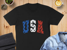 Load image into Gallery viewer, Black t-shirt with distressed USA text in red, white, and blue stars.
