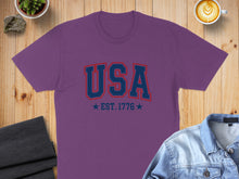 Load image into Gallery viewer, Purple t-shirt with "USA" and "EST. 1776" in red and blue.
