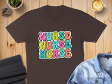 Load image into Gallery viewer, Brown t-shirt with colorful "NURSE" text in rounded letters.

