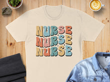 Load image into Gallery viewer, Cream t-shirt with "NURSE NURSE NURSE" text in colorful retro font.
