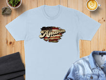 Load image into Gallery viewer, Light blue t-shirt with a distressed American flag graphic and "America" text.
