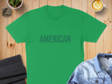 Load image into Gallery viewer, Green t-shirt with "AMERICAN" text, laid flat with coffee and clothing.
