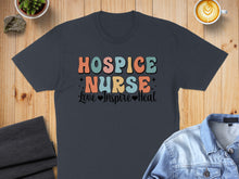 Load image into Gallery viewer, Dark t-shirt with "HOSPICE NURSE Love Inspire Heal" text in colorful retro font.
