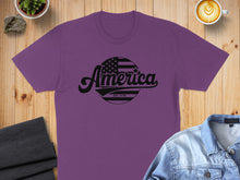 Load image into Gallery viewer, Purple t-shirt with "America Est. 1776" text inside a star-spangled banner circle.
