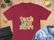Load image into Gallery viewer, Maroon t-shirt with colorful "Teach Love Inspire" text.
