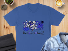 Load image into Gallery viewer, Blue t-shirt with peace sign, heart, and dental graphics, reading "Peace love dental".

