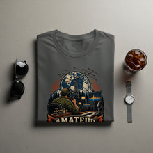 Load image into Gallery viewer, T-shirt with illustration of a person operating ham radio equipment with "AMATEUR" text.
