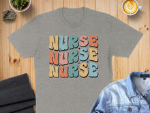 Load image into Gallery viewer, Grey t-shirt with "NURSE" in colorful retro font.
