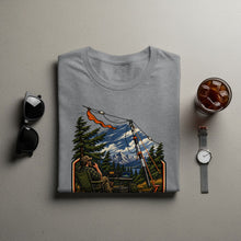 Load image into Gallery viewer, T-shirt graphic shows a person operating a ham radio in a mountain landscape.

