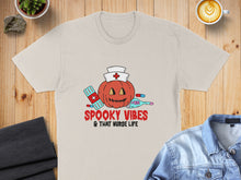 Load image into Gallery viewer, Cream t-shirt with "Spooky Vibes &amp; That Nurse Life" text and Halloween-themed nurse graphics.
