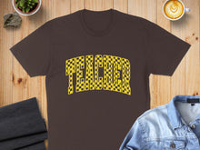 Load image into Gallery viewer, Brown t-shirt with "TEACHER" text in a yellow and black checkered pattern.
