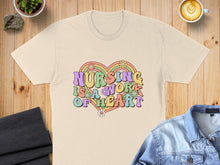 Load image into Gallery viewer, "Nursing is a work of heart" text with colorful flowers on a light yellow t-shirt.
