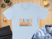 Load image into Gallery viewer, Light blue t-shirt with "TEACHER" in colorful stripes and words below.
