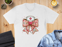 Load image into Gallery viewer, White t-shirt with a nurse's hat and stethoscope bow design featuring "xoxo".
