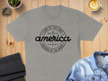 Load image into Gallery viewer, Grey t-shirt with circular "Land of the Free Since 1776 Because of the Brave America" graphic.
