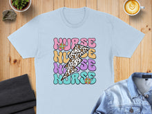 Load image into Gallery viewer, Light blue t-shirt with colorful "NURSE" text and lightning bolt graphics.
