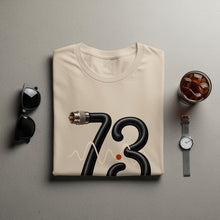 Load image into Gallery viewer, Cream t-shirt with black "73" graphic, waveform, and red dot.
