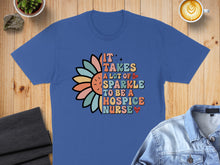 Load image into Gallery viewer, Blue t-shirt with colorful text and flower design: "IT TAKES A LOT OF SPARKLE TO BE A HOSPICE NURSE".
