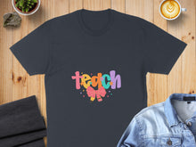 Load image into Gallery viewer, Dark t-shirt with colorful "teach" text and a pink bow graphic.
