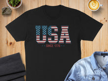 Load image into Gallery viewer, Black t-shirt with "USA SINCE 1776" in patriotic flag design.

