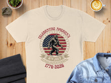 Load image into Gallery viewer, Cream t-shirt with Bigfoot in front of US flag and "Celebrating America's 4th July Semiquincentennial 1776-2026" text.
