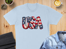 Load image into Gallery viewer, Light blue t-shirt with "USA" graphic in distressed American flag print.
