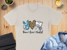 Load image into Gallery viewer, T-shirt with "Peace love Dental" graphic featuring a peace sign, leopard heart, and tooth.

