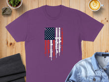 Load image into Gallery viewer, Purple t-shirt with American flag design featuring rifles.
